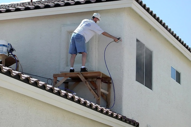 Homme qui fait un ravalement de façade