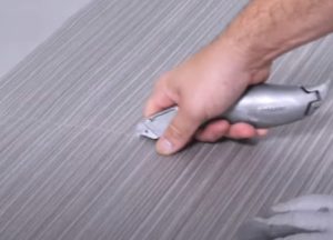 Artisans qui découpe du balatum avec un cutter
