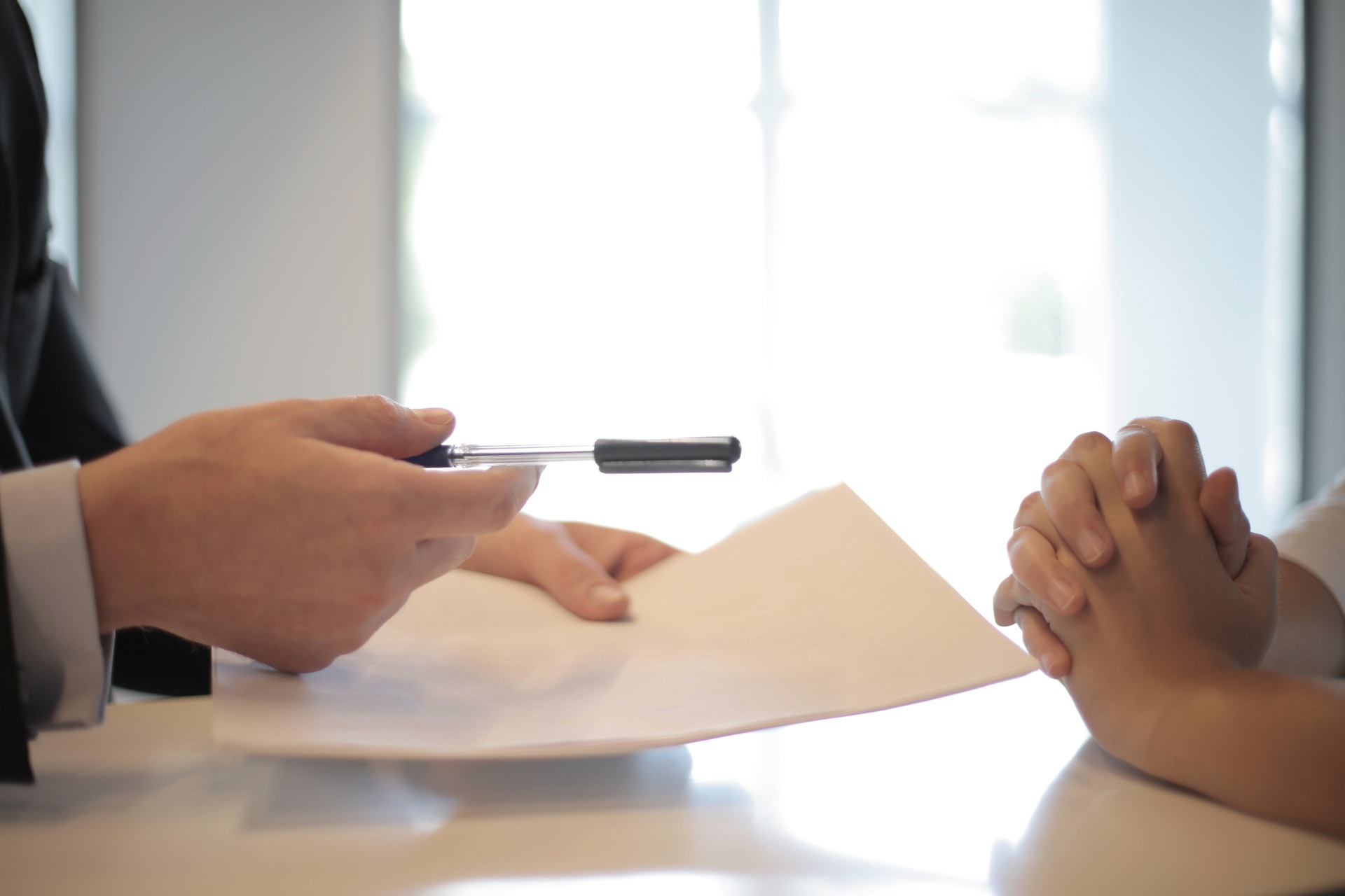 assureur tend stylo et feuille contrat assurance prêt à signer