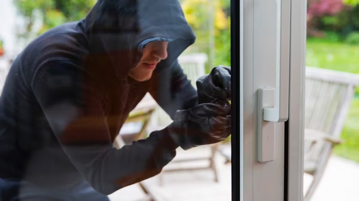 Cambrioleur qui tente d'entrer dans une maison