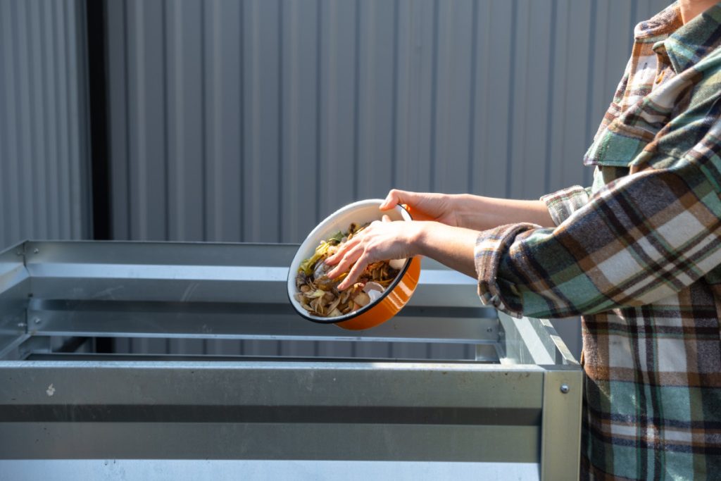 Une femme verse des déchets alimentaires 