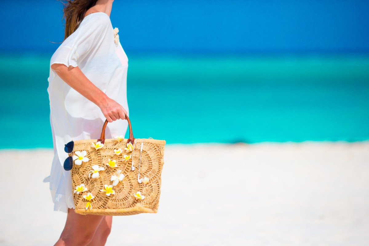 Femme qui tient dans sa main un sac de plage personnalisé