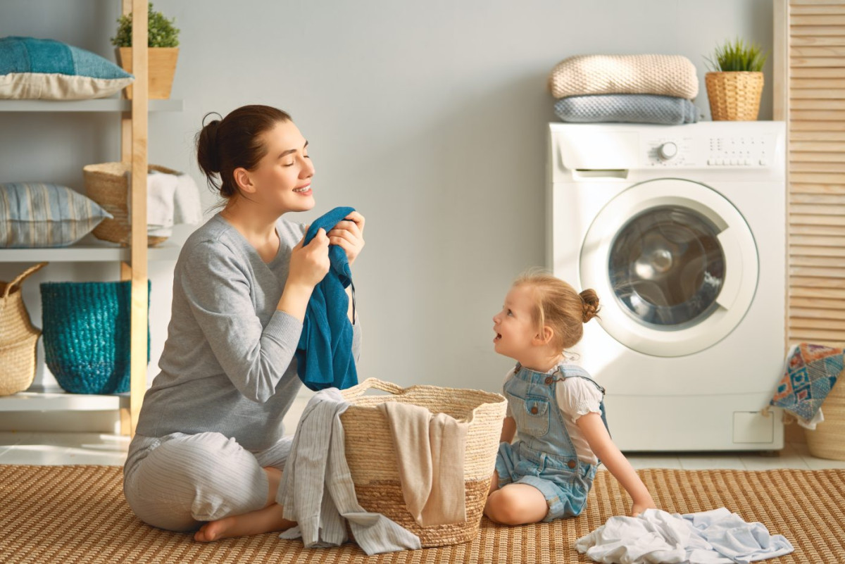 Femme qui sent sa lessive avec sa petite fille