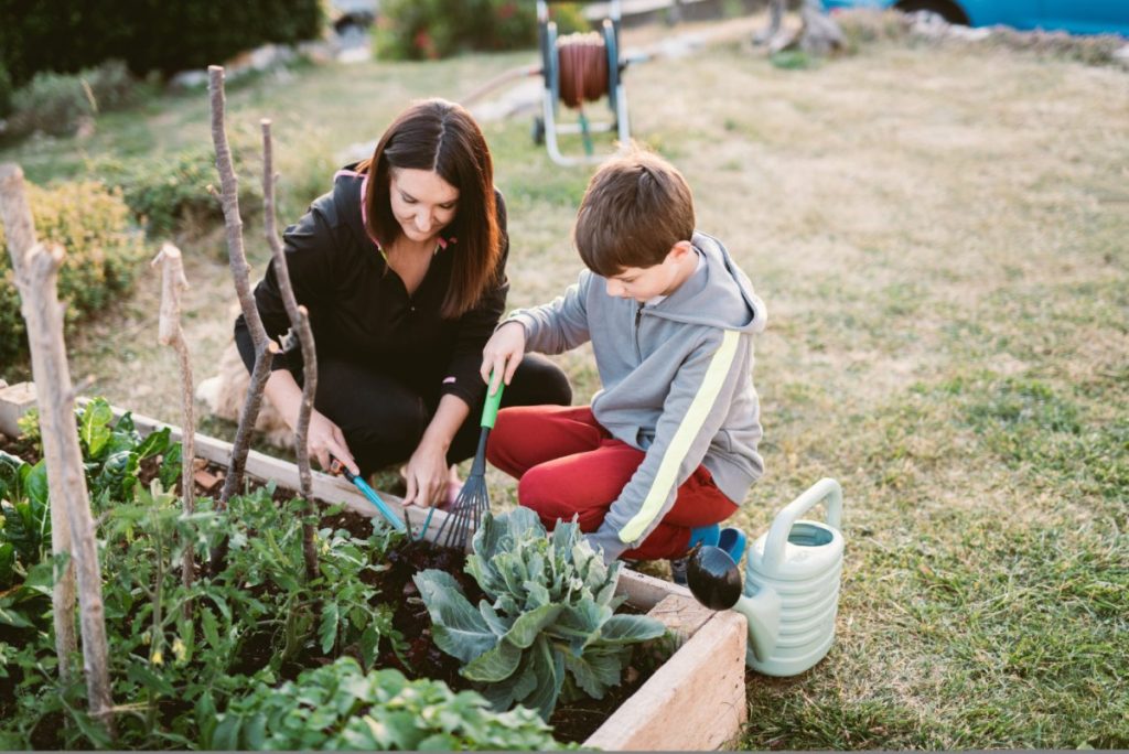 Enfant garçon qui jardine avec sa mère
